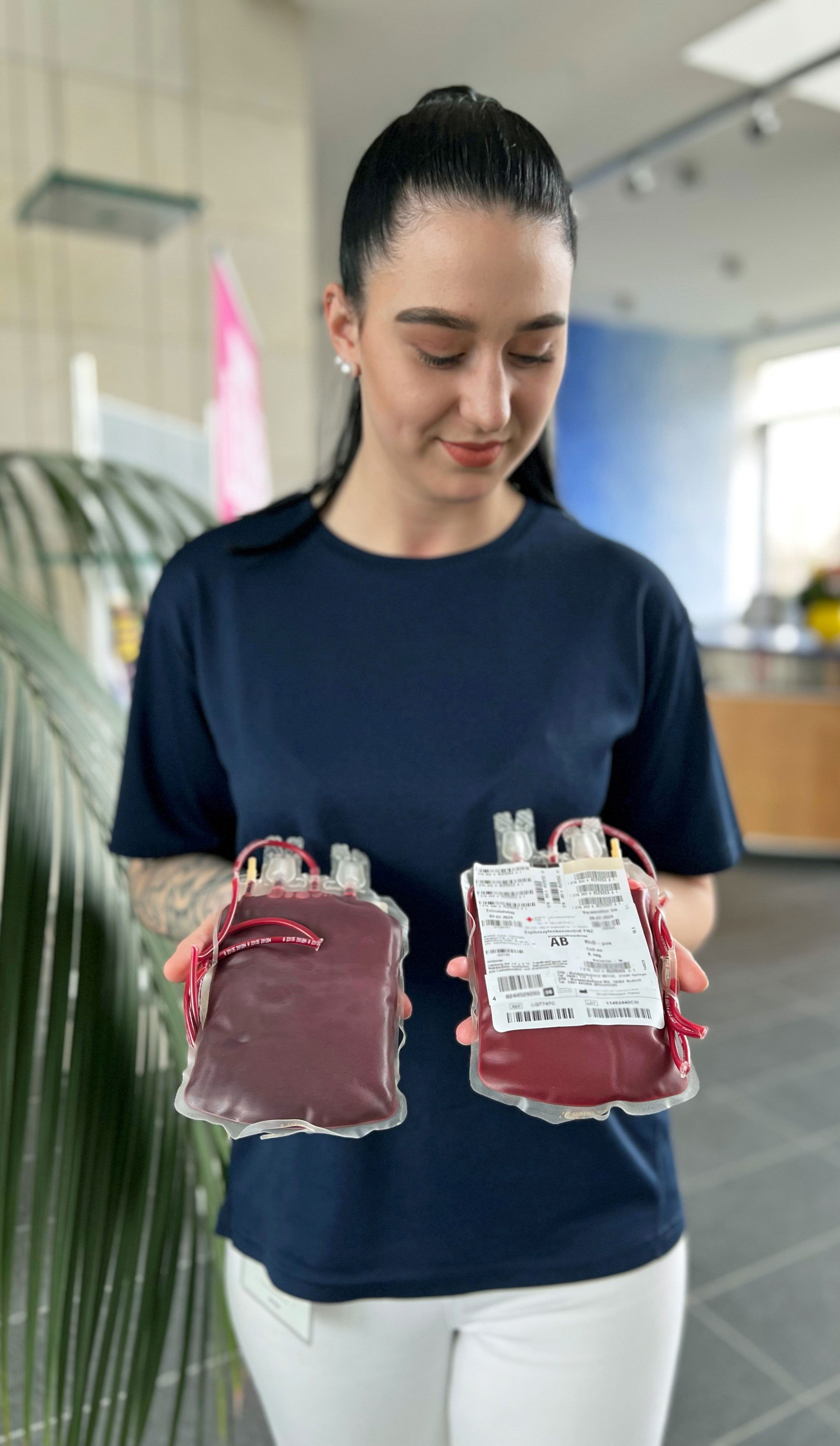 Mitarbeiterin zeigt zwei Blutbeutel